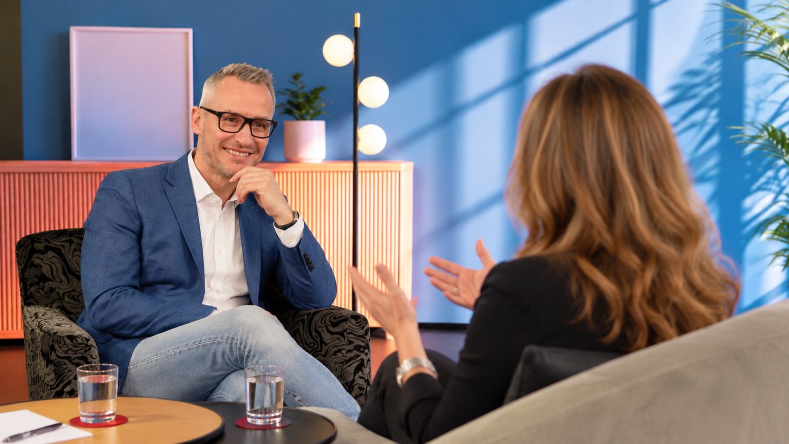 Mike Metelko im Gespräch mit einer Klientin, beide sitzen sich in einem hellen Studio gegenüber