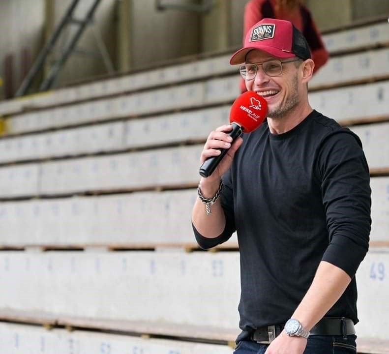 Mike Metelko mit Mikrofon auf einer Stadiontribuene